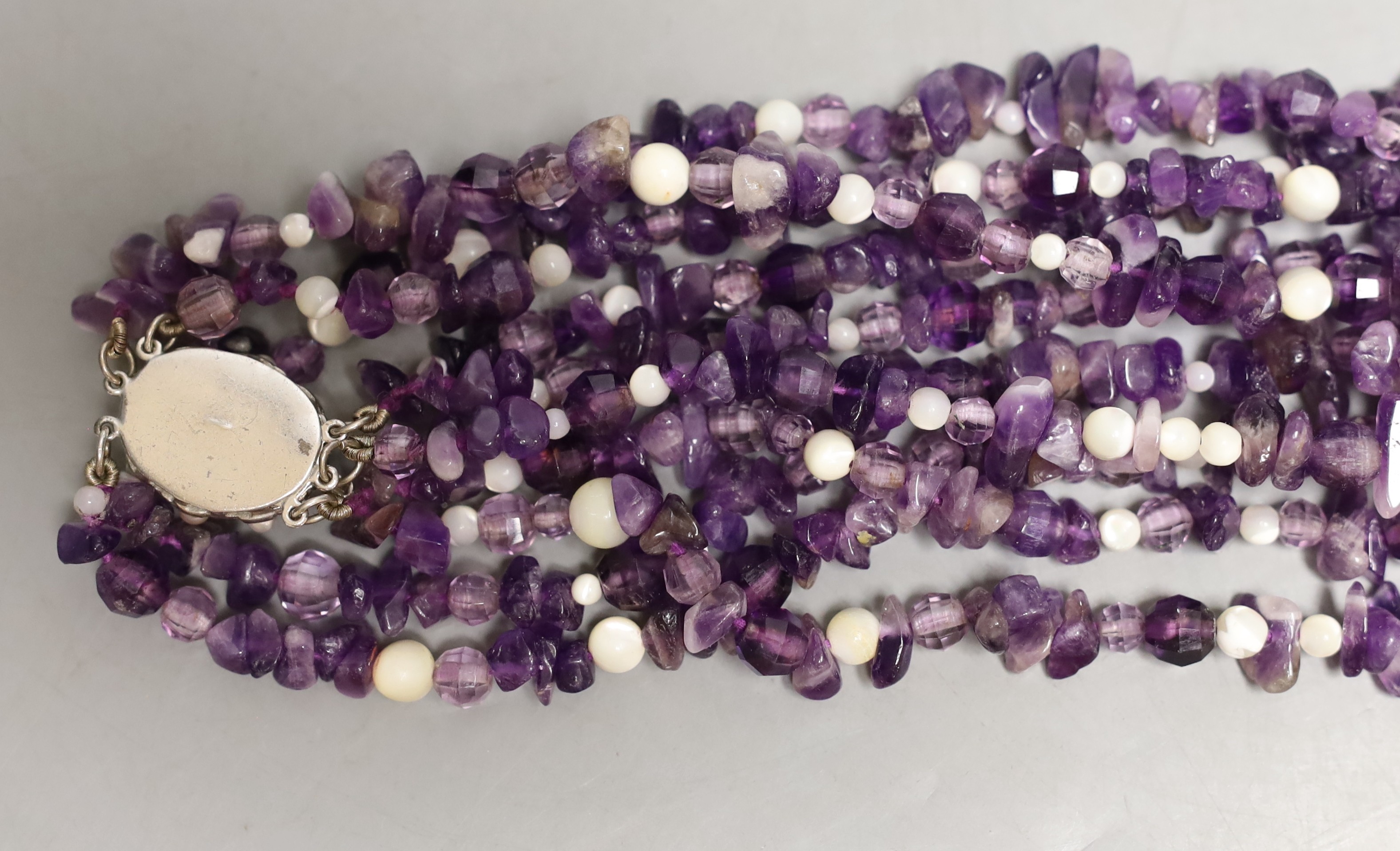 A quadruple strand amethyst pebble necklace, with white bead spacers and white metal clasp, 50cm